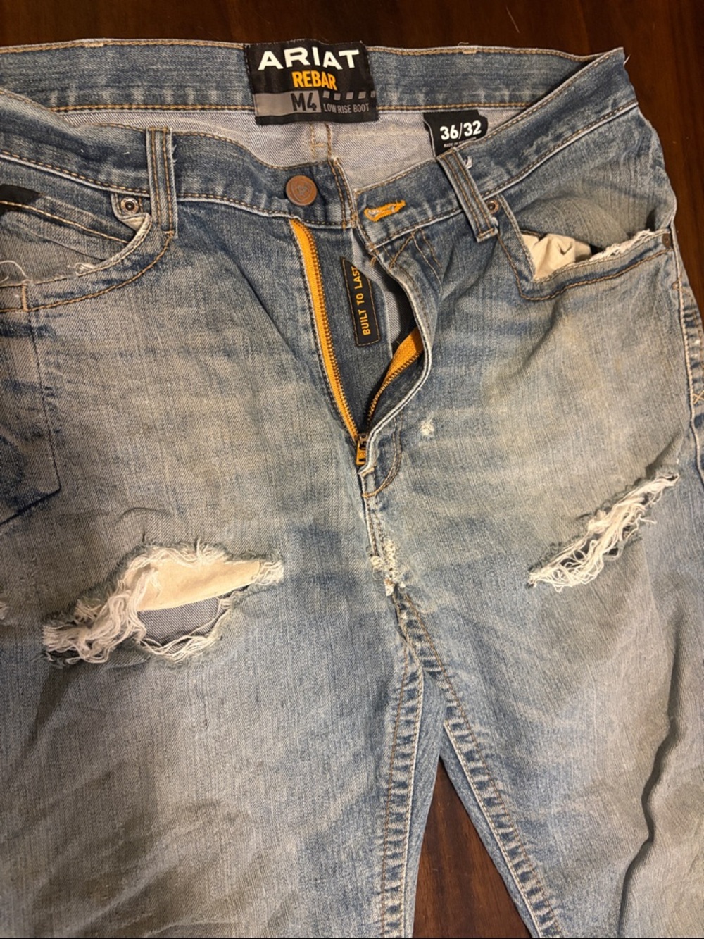 Ariat light blue distressed Rebar jeans with yellow zipper